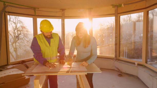 istock LENS FLARE: Female investor points at floor plans while talking to contractor 1300970661