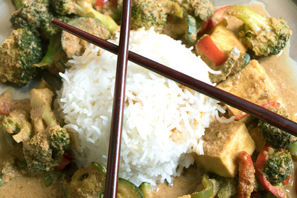 reismehl mit brokkoli, tofu und rotem paprikacurry - tofu chinese cuisine vegetarian food broccoli stock-fotos und bilder