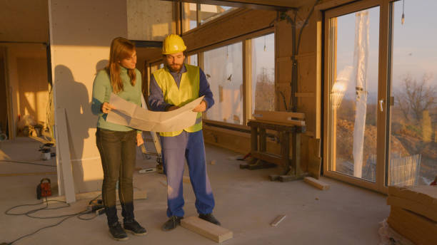 istock Experienced architect shows home owner around the unfinished house at sunset 1300970779
