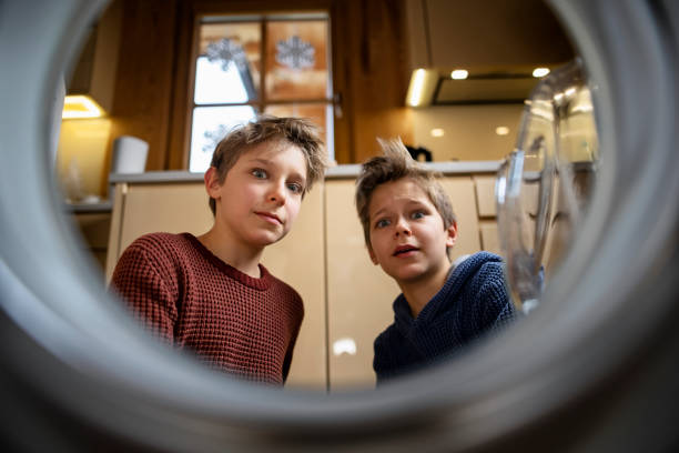 istock Two boys opening a washing machine and discovering laundry disaster 1300970780