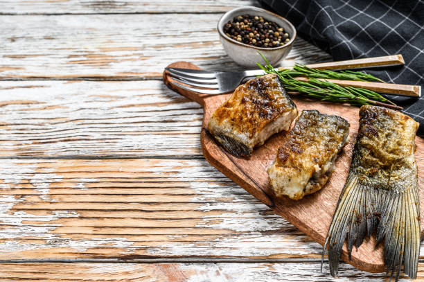 istock Baked sliced silver carp. Wooden background. Top view. Copy space 1300971226