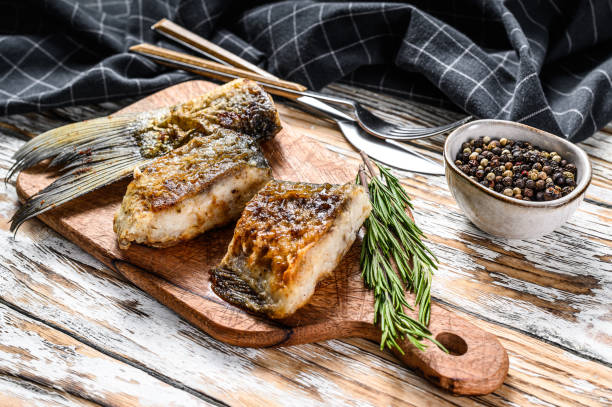 Baked sliced silver carp. Wooden background. Top view