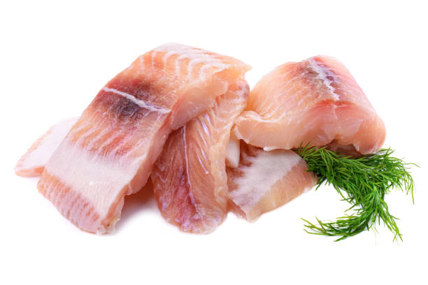 istock Pangasius fish fillet, pieces on a green lettuce leaf. Isolated on a white background. Fresh Fish Fillet. 1300971792
