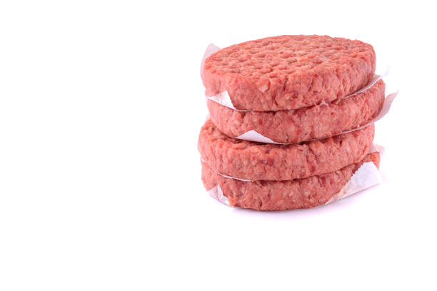 istock Raw beef patties for making a burger.Isolated on a white background.Selective Focus. 1300971813