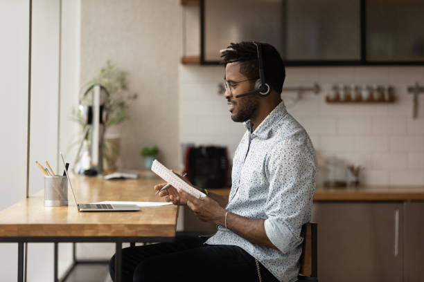 istock Black male student in headset discussing test via online conference 1300971862