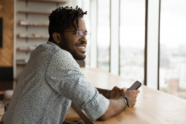 istock Stylish young black guy enjoy weekend at home with smartphone 1300971881