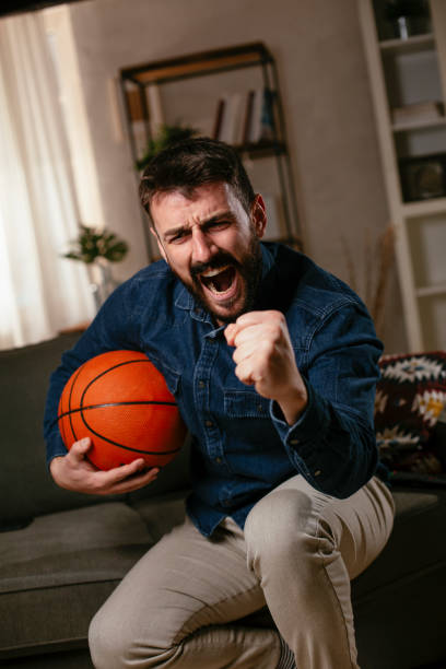 istock Man watching sports game on tv 1300972452