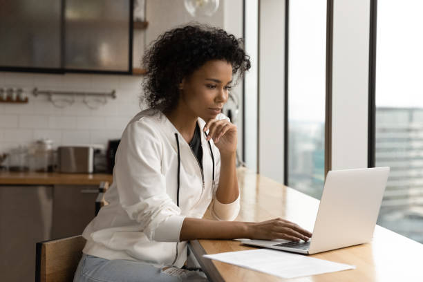istock Young african female work online using laptop at modern apartment 1300972470