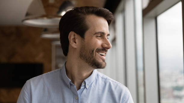 istock Optimistic young man looking at window thinking of good opportunities 1300972572