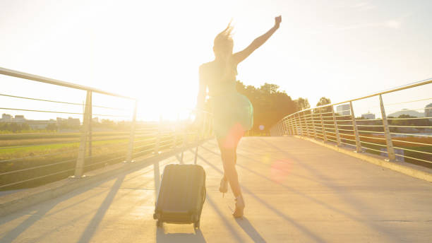 lens flare: fashionable blonde tourist girl is excited to go on another trip - shoe leaving women summer imagens e fotografias de stock