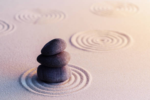 istock Meditation zen garden with stones on sand 1300973416
