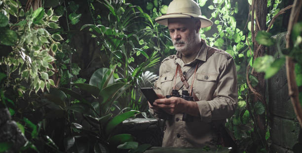istock Adventurer exploring the forest and connecting online 1300973731