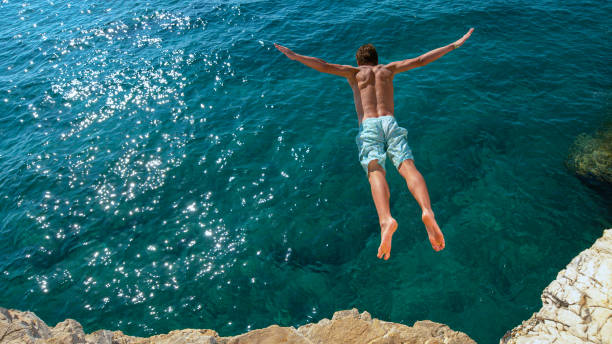 istock COPY SPACE: Young man on a summer vacation does cliff diving on a sunny day. 1300974465