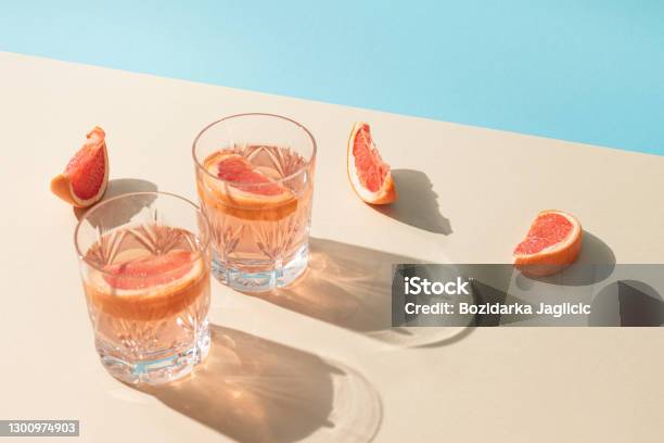Zwei Gläser Getränk Mit Scheiben Frischer Grapefruit Vor Hellem Beigem Und Blauem Hintergrund Kreatives Minimalsommerkonzept Sonnige Tag Schatten Stockfoto und mehr Bilder von Cocktail