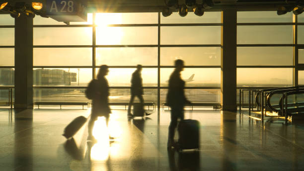 istock SILHOUETTE: Commuters rush with their suitcases across a busy airport terminal. 1300974955