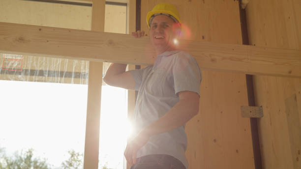 istock PORTRAIT: Cheerful worker smiles for camera while carrying a plank across room 1300976395