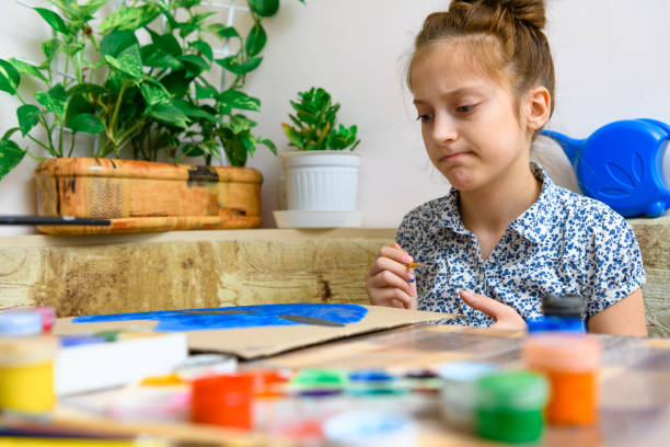 istock a girl drawing blue gouache cardboard, artistic creation at home, makes creative artwork 1300976997