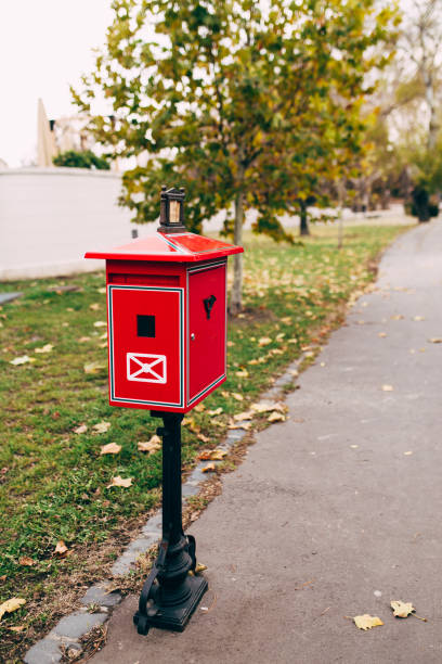istock Red metal mailbox on the street. Blurred background 1300977367