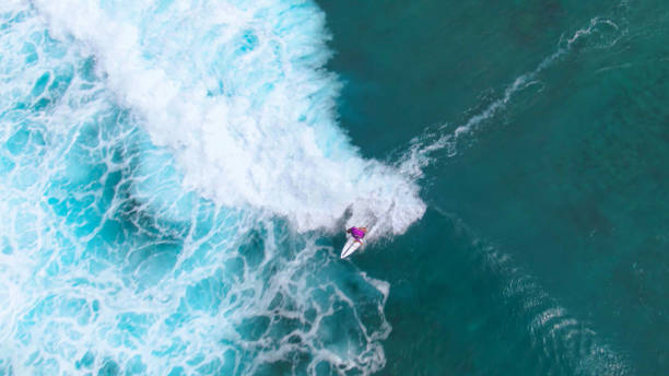 istock TOP DOWN: Cool surfer dude rides a massive foaming wave heading to the Maldives. 1300978065