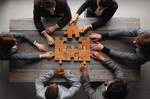 Business teamwork with puzzle finishing project cooperation unity concept
