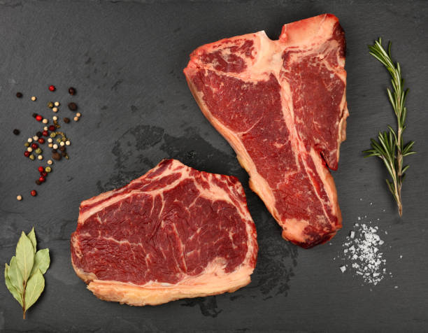 istock Close up raw beef steaks on black slate board 1300982129