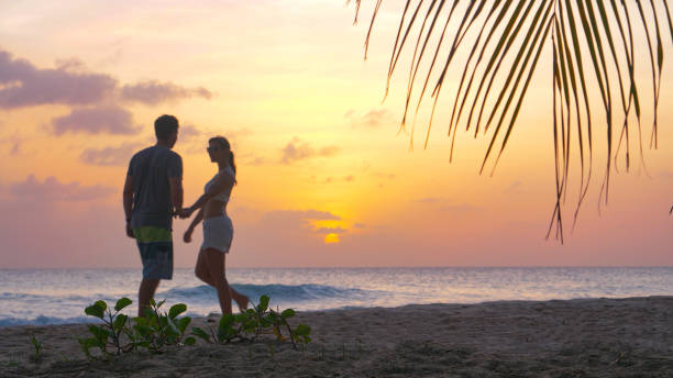istock LOW ANGLE: Young man and woman on vacation go for a stroll on a sunny evening. 1300982500
