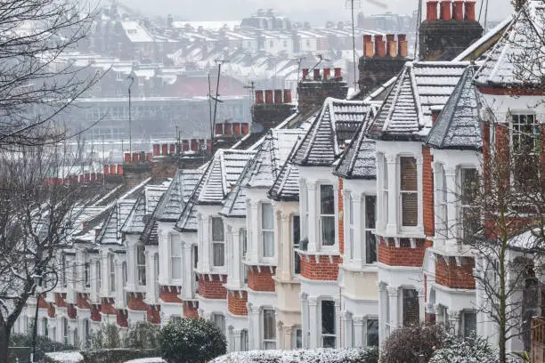 Row of identical English terraced houses covered by snow in Crouch End, North London