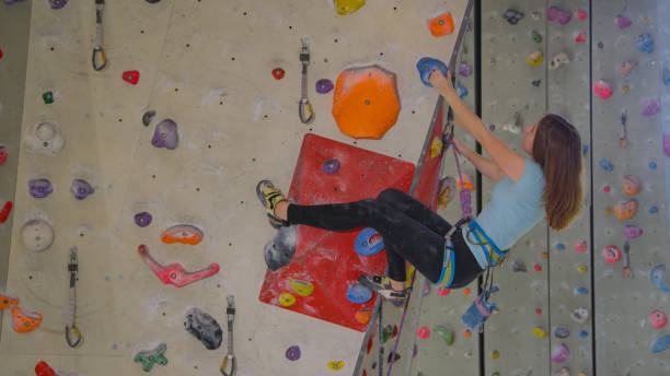 istock CLOSE UP: Focused teenager climbs a difficult route while lead climbing indoors. 1300984437