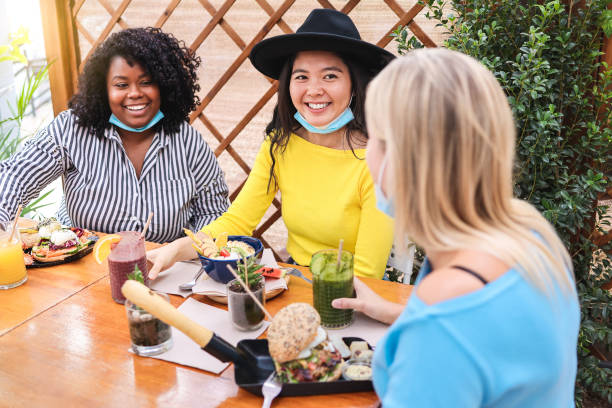 istock Young multiracial people having breakfast in restaurant outdoors during coronavirus outbreak - Focus on asian girl 1300986490