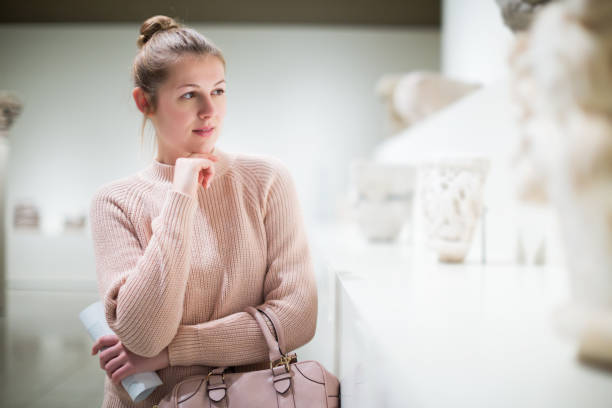 istock woman with guidebook standing in museum 1300987364