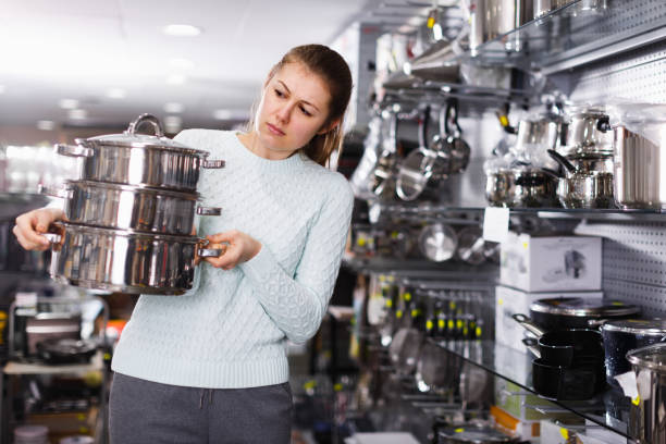 istock Nice female is buying new saucepan 1300987370