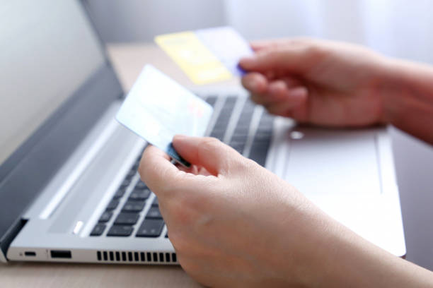 istock Credit cards in female hands on laptop background 1300987601