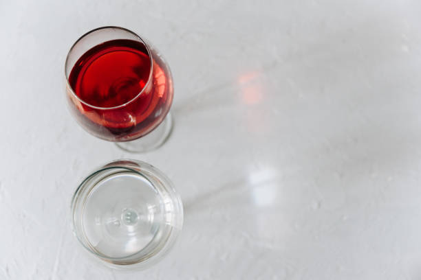 istock two wine glasses on a grey background one with red wine and the other with water 1300991929