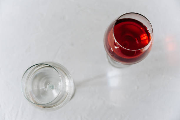 istock two wine glasses on a grey background one with red wine and the other with water 1300992412