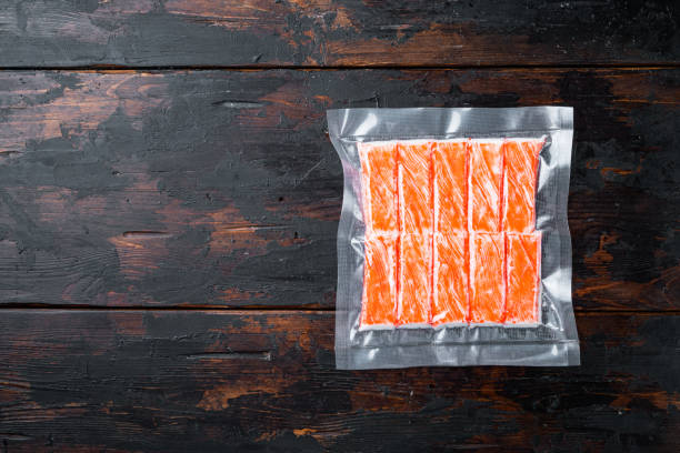 istock Crab stick surimi vacuum pack, on dark wooden background, top view flat lay  , with copyspace  and space for text 1300992514