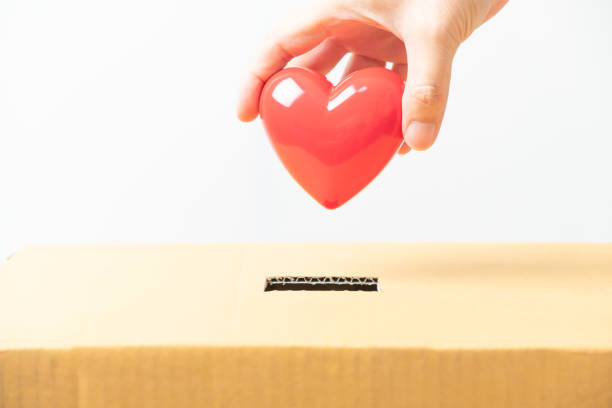 istock Hand holding red heart put into donating the box, donating hearts to make merit concept 1300993338