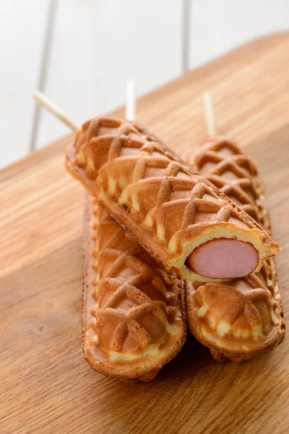 istock Few corn dogs on a wooden cutting board 1300993895