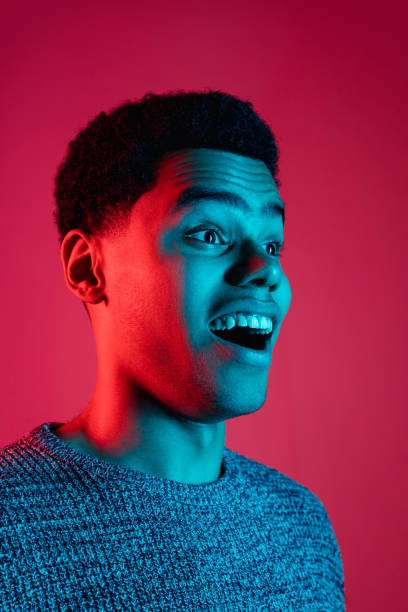 istock African-american man's portrait isolated on red studio background in multicolored neon light 1300994808