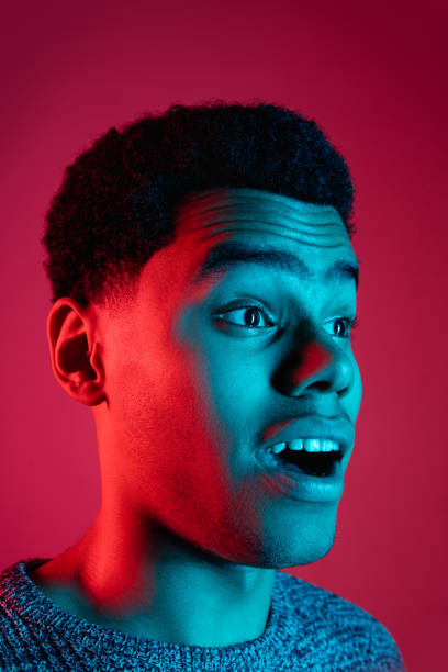 istock African-american man's portrait isolated on red studio background in multicolored neon light 1300994815