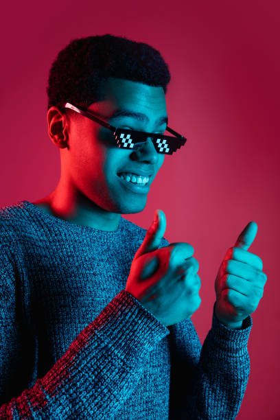 istock African-american man's portrait isolated on red studio background in multicolored neon light 1300994817
