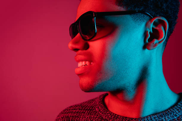 istock African-american man's portrait isolated on red studio background in multicolored neon light 1300994819