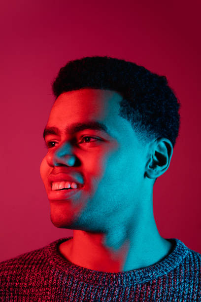 istock African-american man's portrait isolated on red studio background in multicolored neon light 1300994837