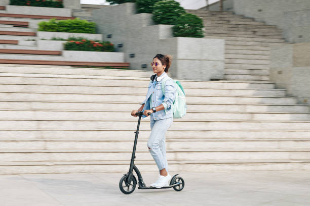 istock Stylish woman riding on electric scooter 1300996290