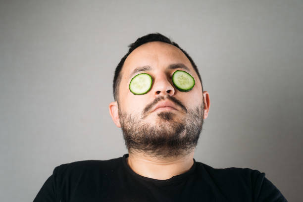 istock Relaxed bearded young man with a hydrating cucumber mask on his face 1300997165