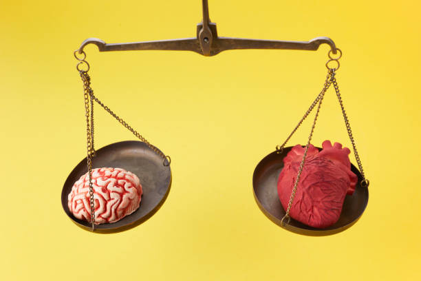 istock Brain and heart on scale balance on yellow background 1300997409