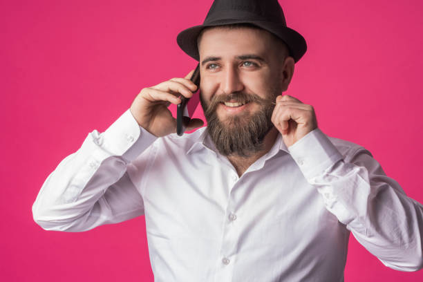 istock young man talking on the phone and holding his beard 1300997603