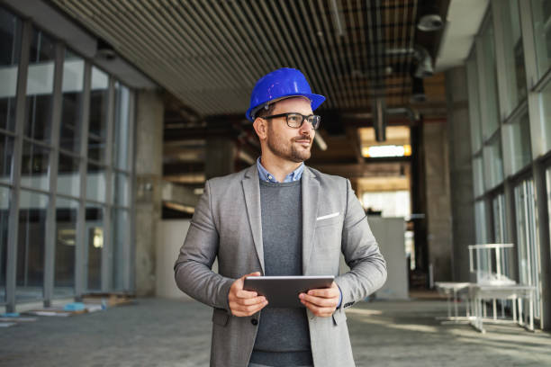 istock Supervisor standing in building in construction process, holding tablet and checking on works. 1300999239