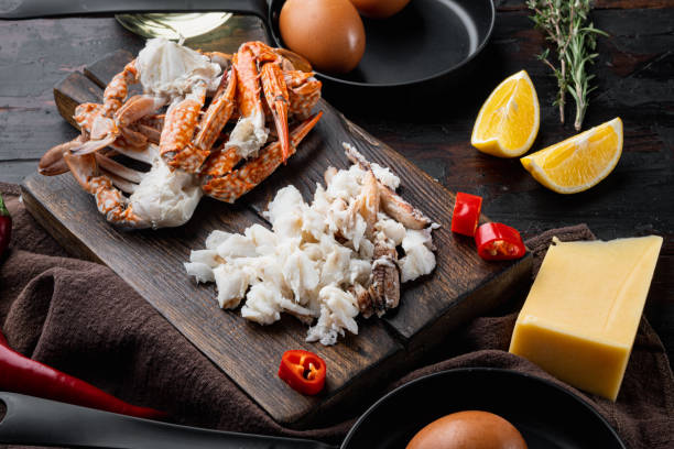istock Spanish or Thai omelette ingredient, fresh red chilli, brown and white crabmeat, lemon, Cheddar cheese, eggs, on dark wooden background 1301000766