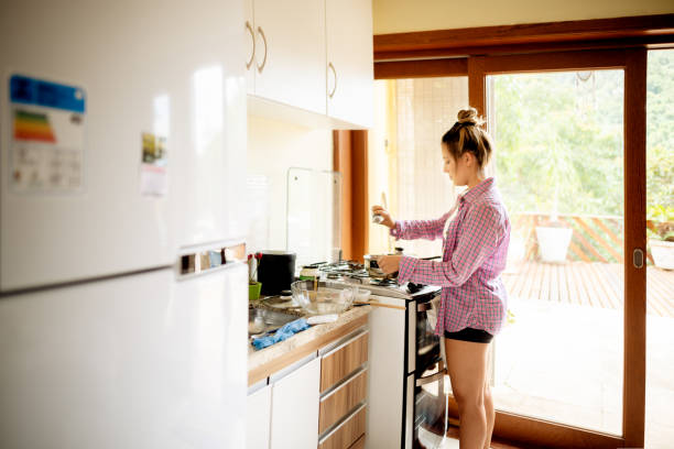 istock Young woman adding salt while cooking dinner at home 1301001786
