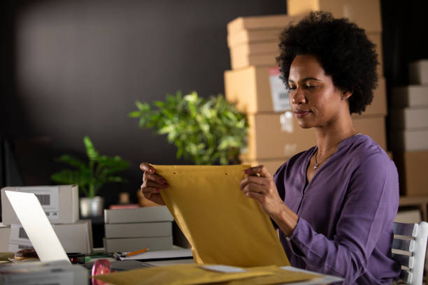 istock Woman closing an envelope she packed customer's order in 1301002691